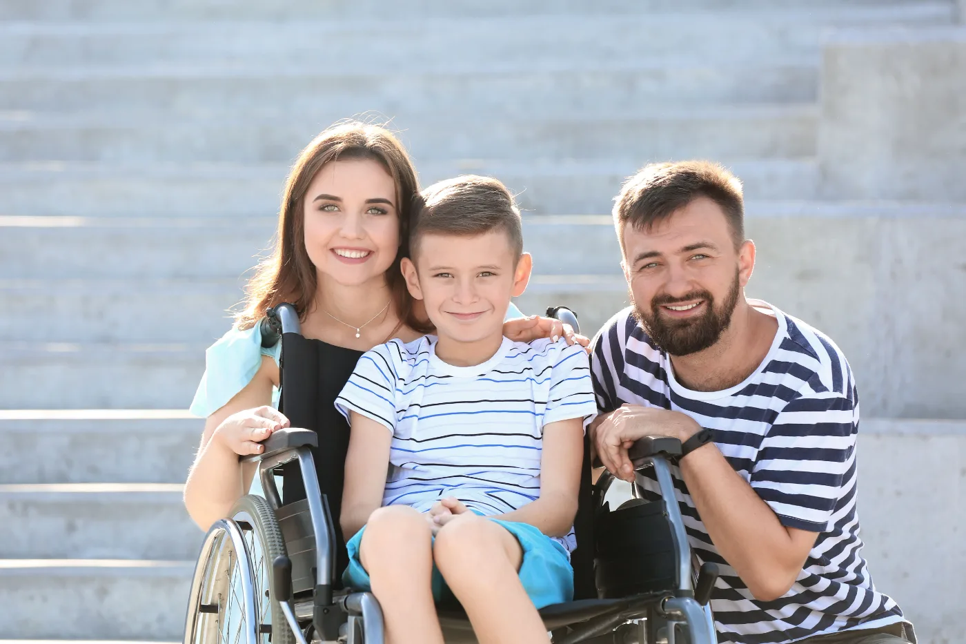A family of four outdoors together, one parent using a wheelchair